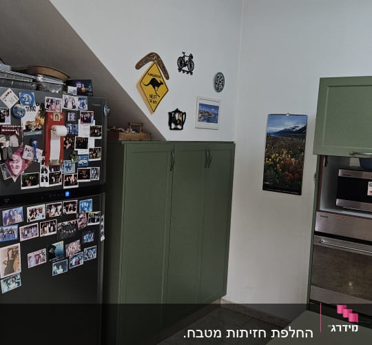 מטבח עם ארונות ירוקים ומקרר עם מגנטים